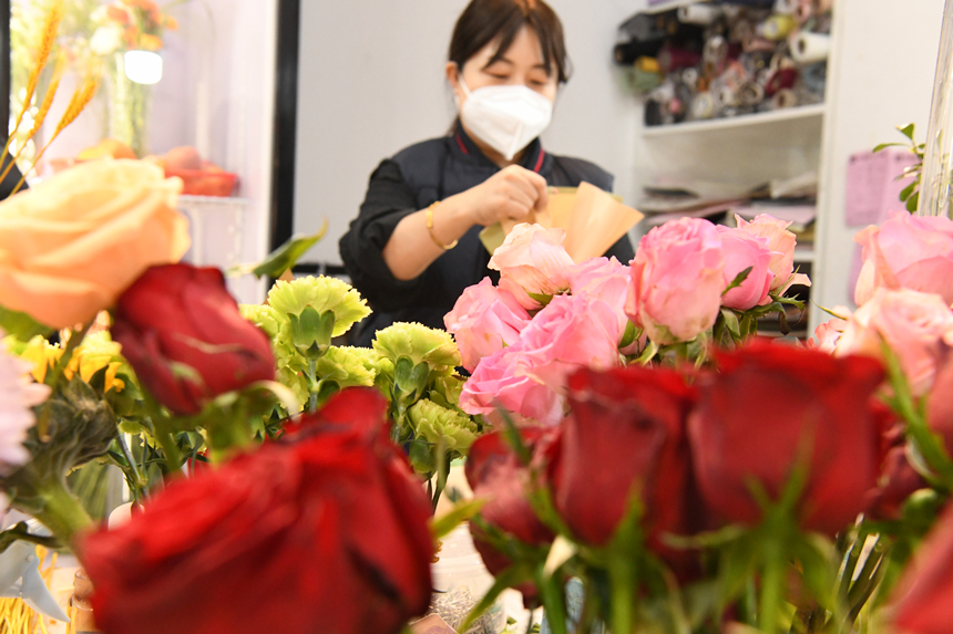 2022年12月31日，河北省邯郸市广平县一家花店内顾客在选购鲜花。程学虎摄