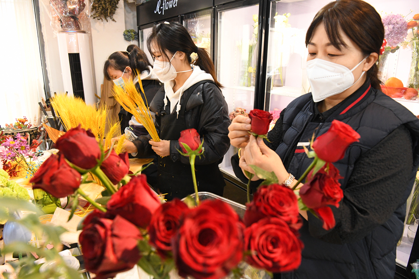 2022年12月31日，河北省邯郸市广平县一家花店内店员在包扎顾客预定的新年花束。程学虎摄