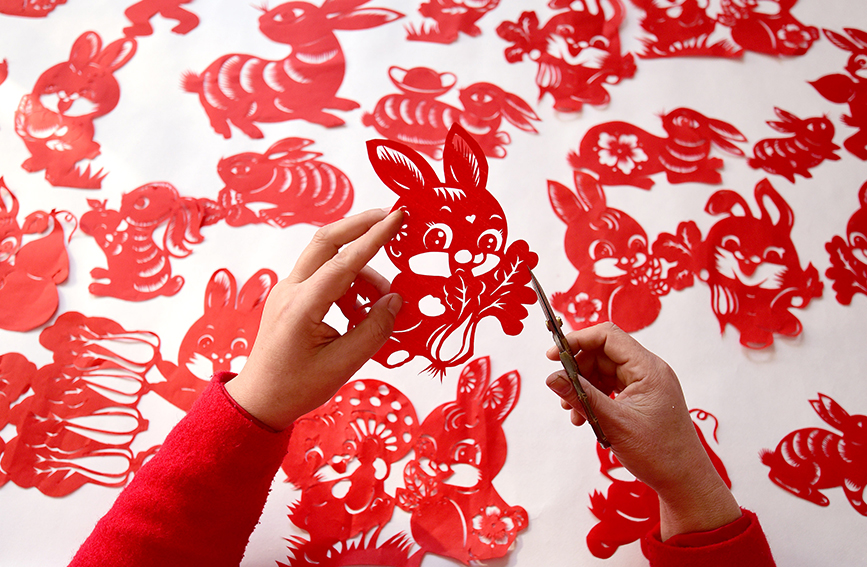 河北省邯郸市复兴区民间剪纸艺人冯石萍在创作兔年剪纸作品。 郝群英摄