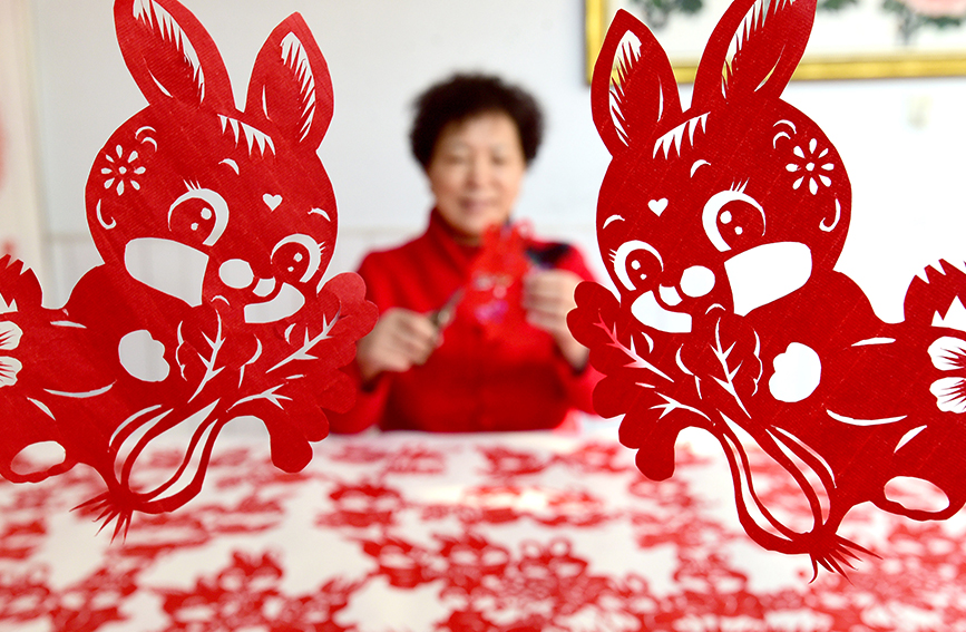 河北省邯郸市复兴区民间剪纸艺人冯石萍在创作兔年剪纸作品。 郝群英摄