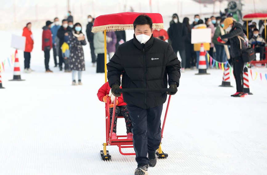 在沧县亲子冰雪趣味运动会上,正在进行雪地黄包车比赛。 周洋摄