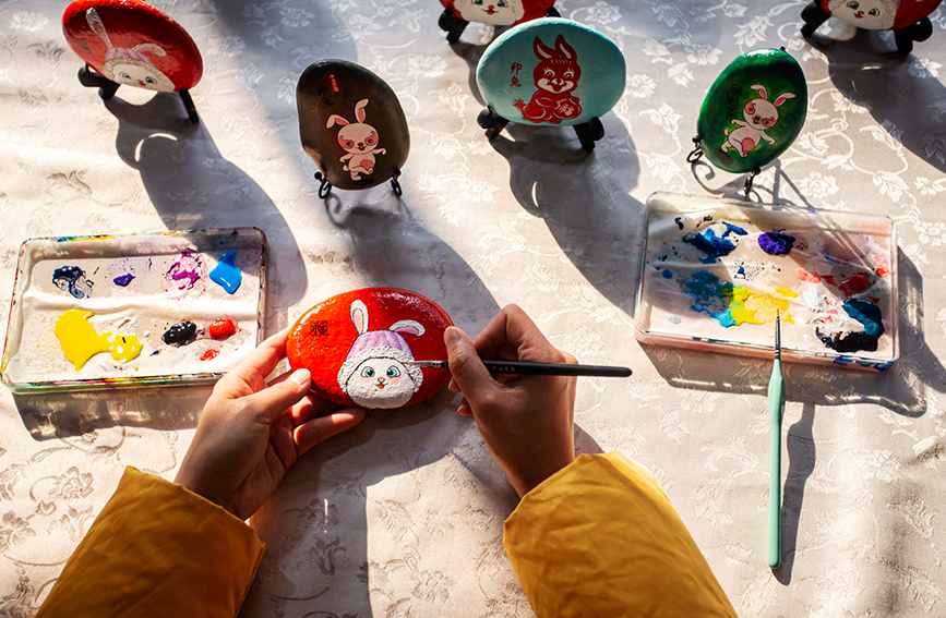 河北省邯郸市复兴区户村镇林村农家女宿静正在创作百兔迎春系列石头画。 聂长青摄