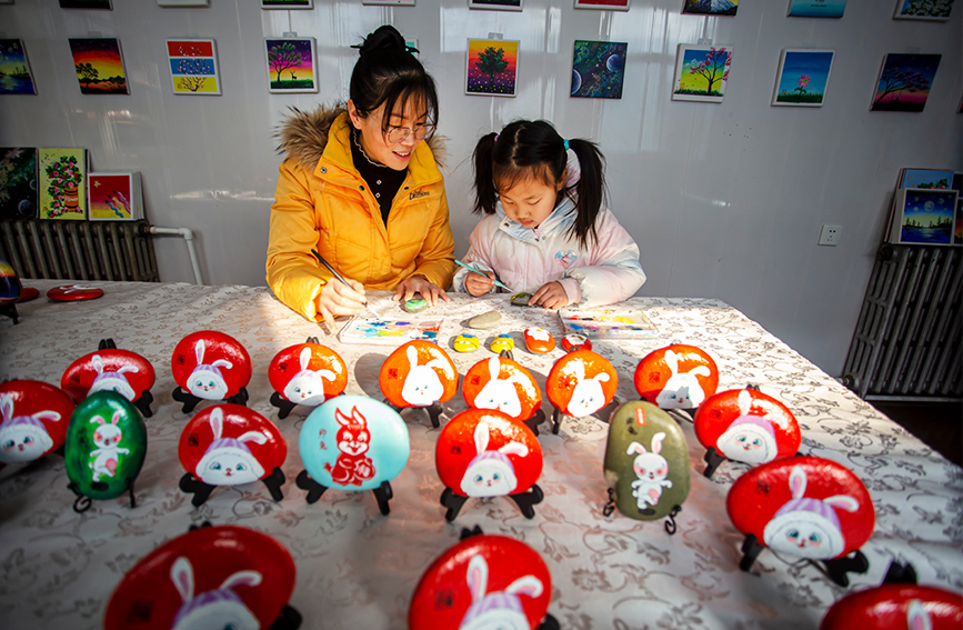 河北省邯郸市复兴区户村镇林村农家女宿静正在辅导小朋友创作石头画。 聂长青摄