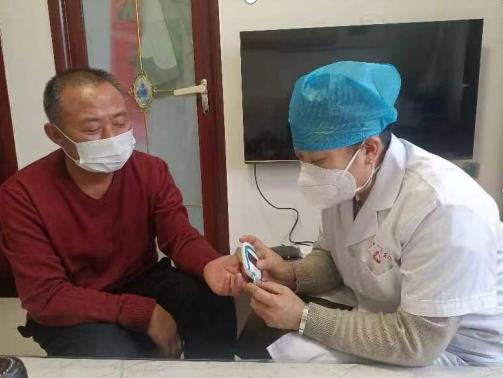 家庭巡诊小分队队员为群众测血糖。 刘晓燕摄