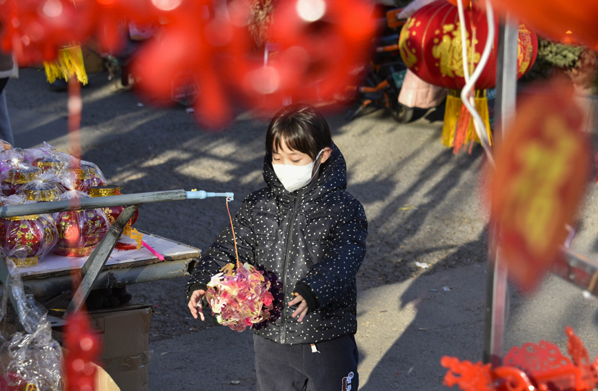 一名儿童在唐山遵化市民俗集市上摆弄玩具。 张旭摄
