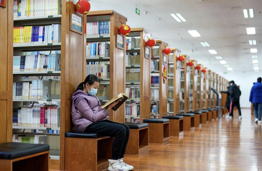 春节假期，一位小姑娘在图书馆中阅读书籍。 赵亮摄