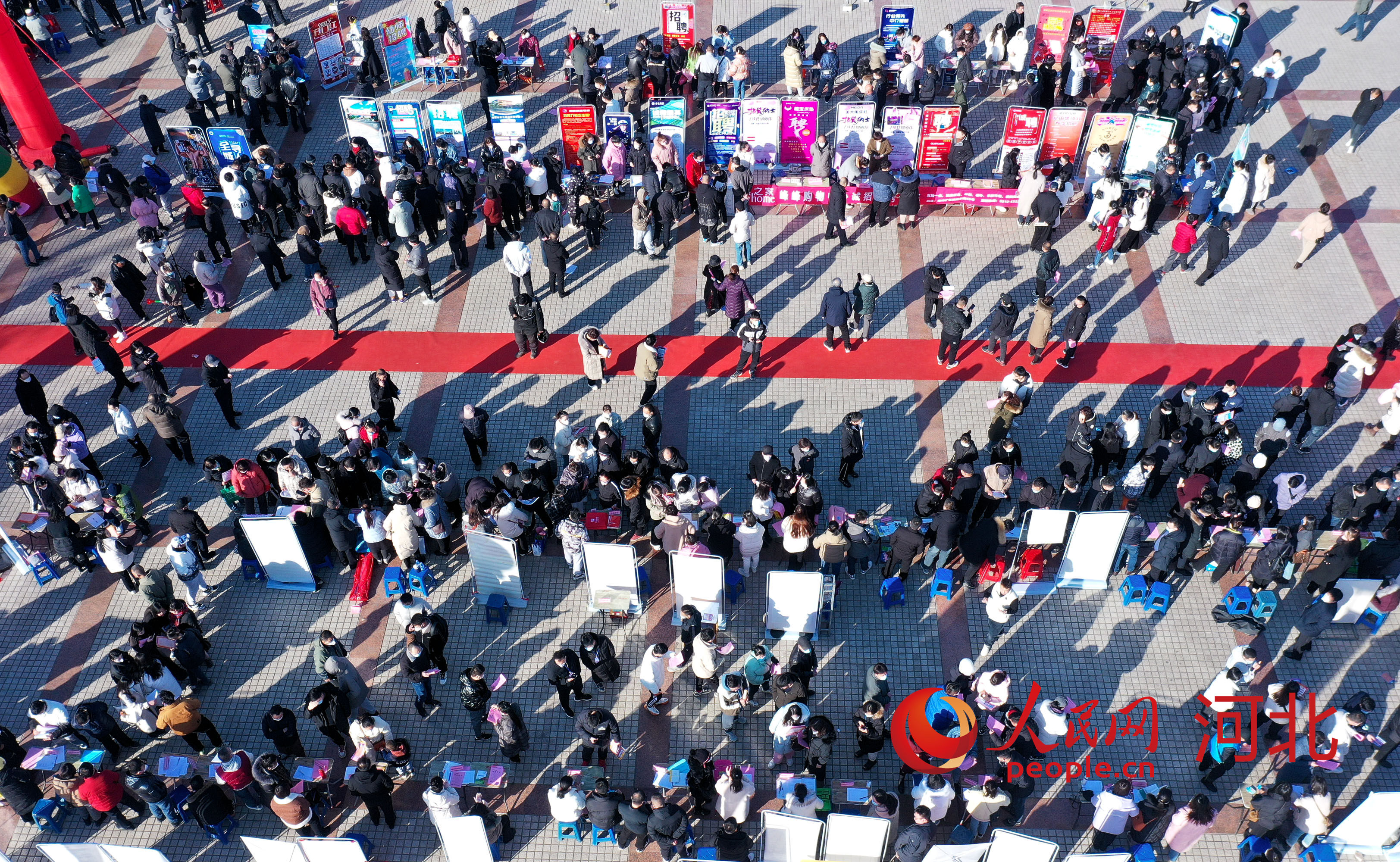 1月30日，在邯郸市峰峰矿区世纪广场，求职者在招聘会现场寻找合适的职位。 人民网 杨文娟摄