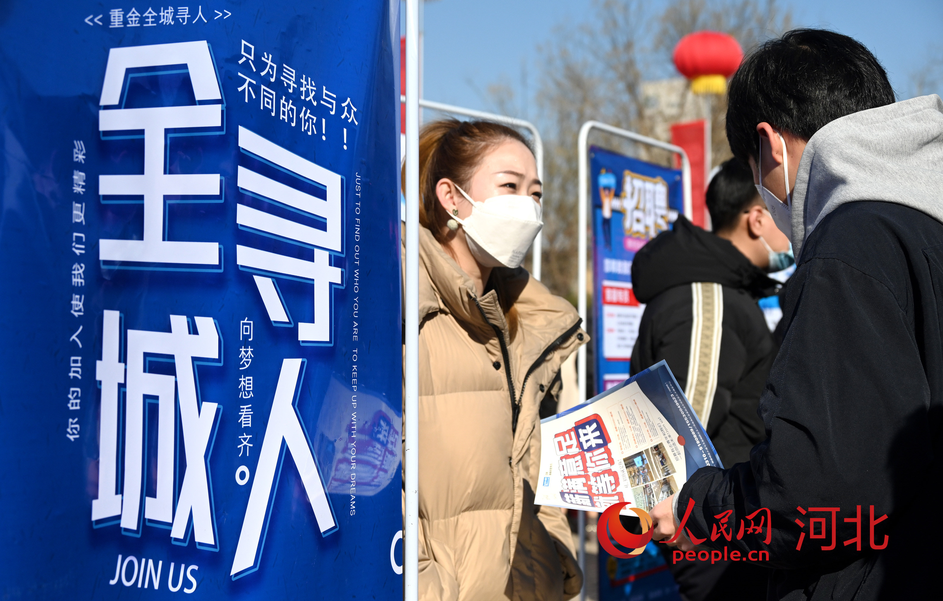 1月30日，在河北省邯郸市峰峰矿区世纪广场，求职者在招聘会现场与用人单位工作人员交流。 人民网 杨文娟摄
