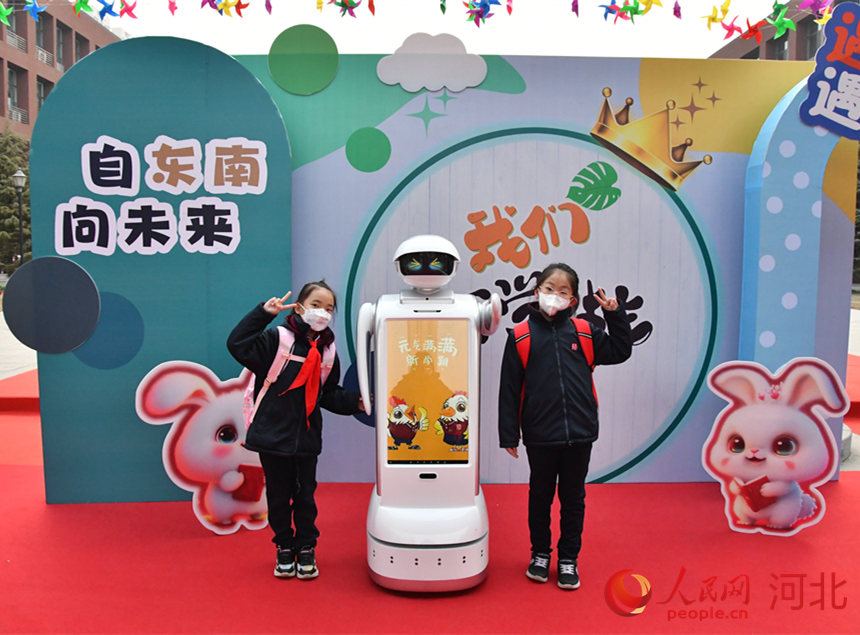 在石家庄市东南实验小学，学生与科技感满满的机器人“小朗”合影。 人民网 杨文娟摄