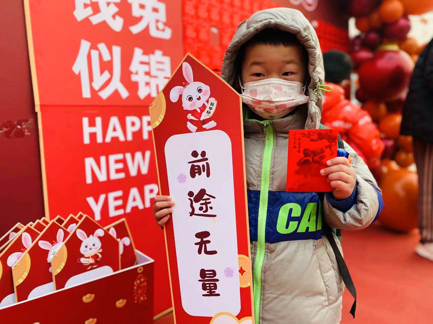邢台市隆尧县实验幼儿园门前为孩子们设置了“幸运红包墙”，一位小朋友领到了自己的红包大奖。 潘志方摄