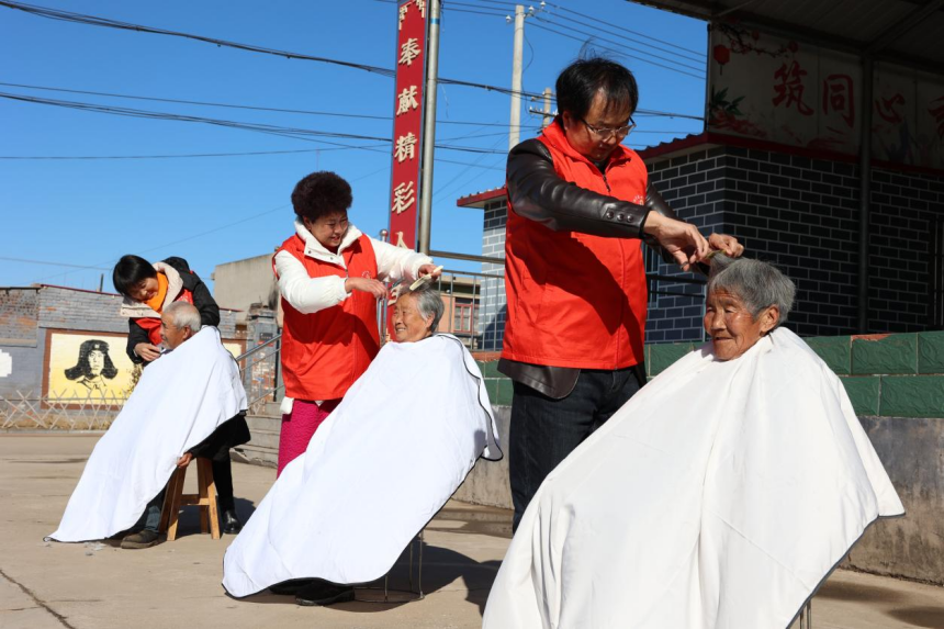 河北省秦皇岛市卢龙翊霏爱心服务中心志愿者在夹河滩村为老人们理发。 张国鹏摄