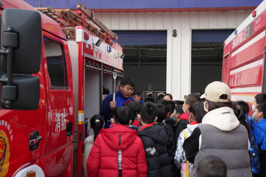 同学们听消防员讲解消防器材的用途。 梁沛龙摄