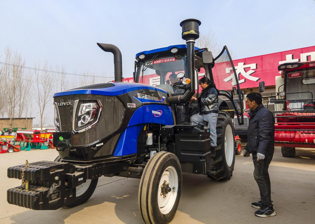 在庞口市场农垦农机营销部，农户试驾大拖拉机。 崔文吉摄