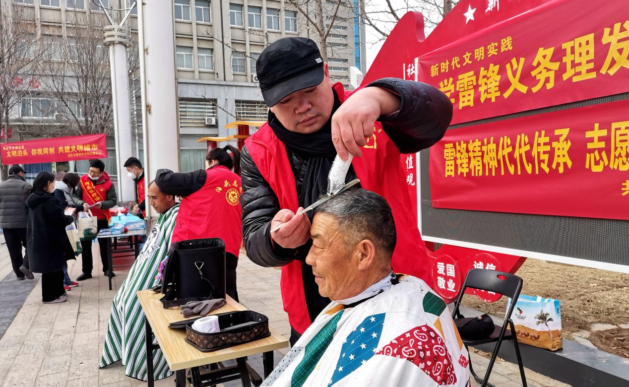 志愿者为市民义务理发。 王丽勤摄