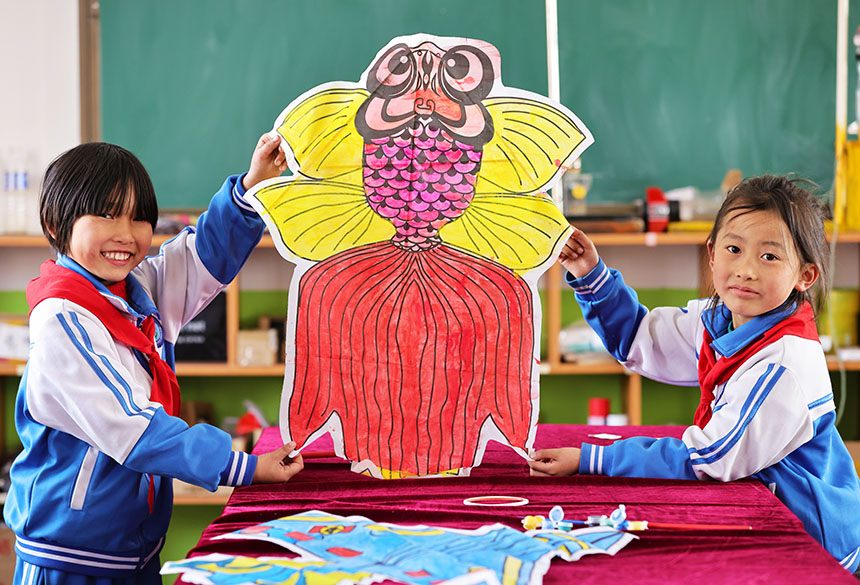 河北省广宗县盐场小学学生在展示彩绘好的“金鱼”风筝。 王垒摄