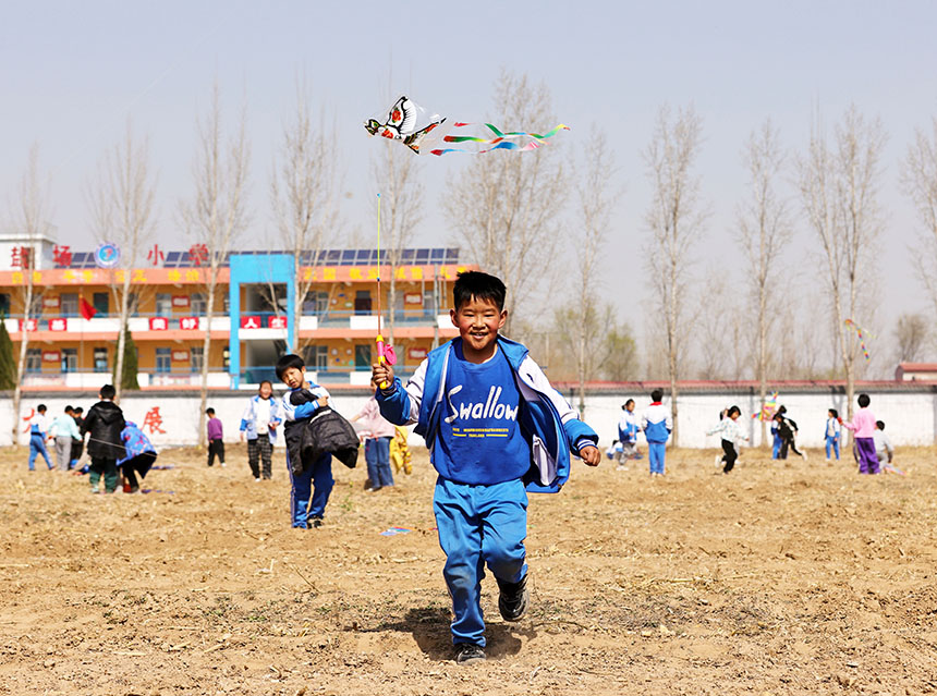 河北省廣宗縣鹽場小學學生在放飛風箏。 王壘攝