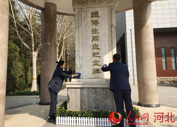 华北军区烈士陵园工作人员为烈士擦拭墓碑。 人民网 杨文娟摄