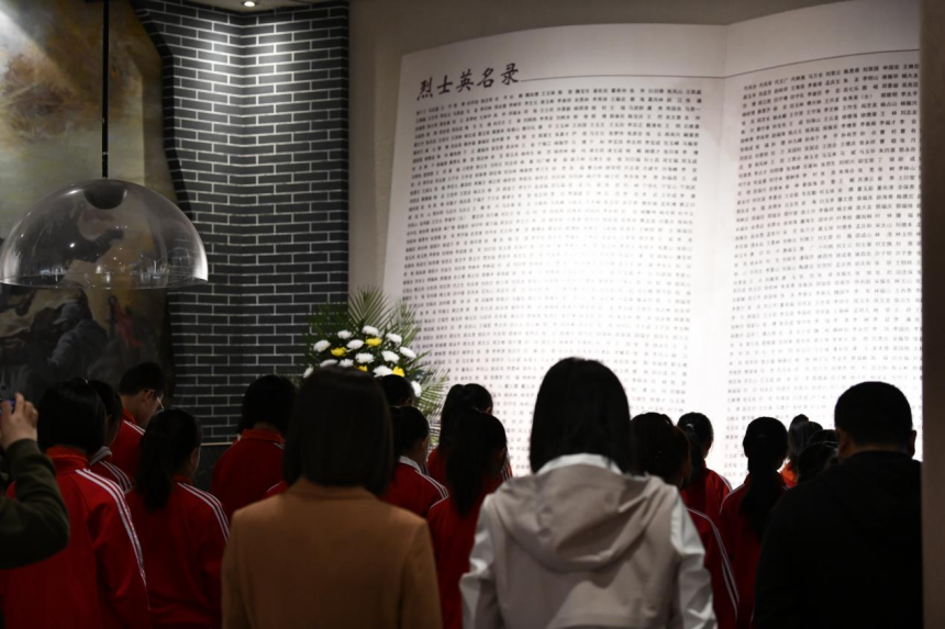 迁安市第四实验小学学生在迁安市博物馆烈士英名录前默哀。 彭月娟摄