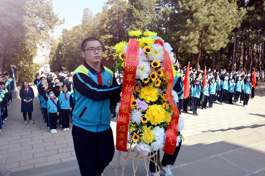 承德市会龙山小学的学生为烈士纪念碑敬献花篮。 李国强摄