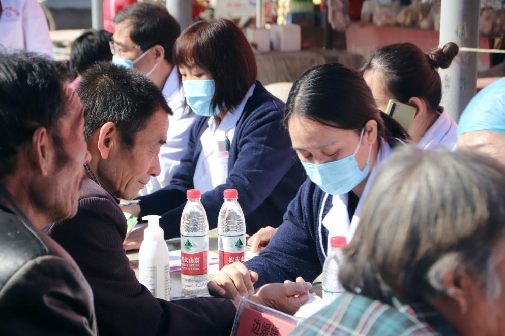 医疗专家为村民把脉问诊。 张光伟摄