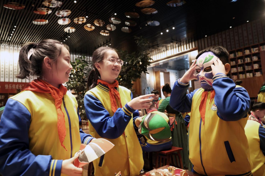 孩子们拿着五彩的京剧脸谱爱不释手。 鲍俊秀摄