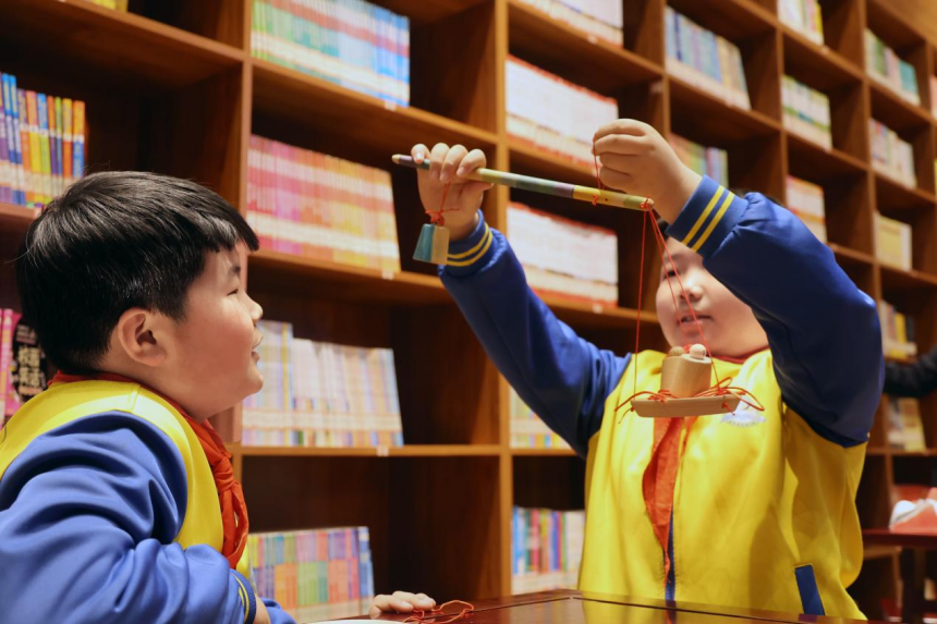 孩子们在练习用杆称称重。 鲍俊秀摄