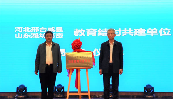 威县教育局局长张延峰（左）和高密市委教育工委副书记张金（右）为“教育结对共建单位”揭牌。 威县教育局供图