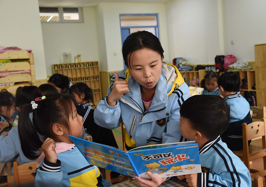 幼儿园教师与孩子们一起学习安全知识绘本。 张占林摄