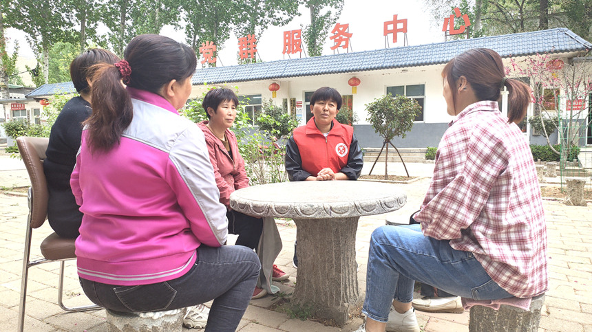志願者和群眾圍坐一起話家常，學政策。 陳亞娟攝