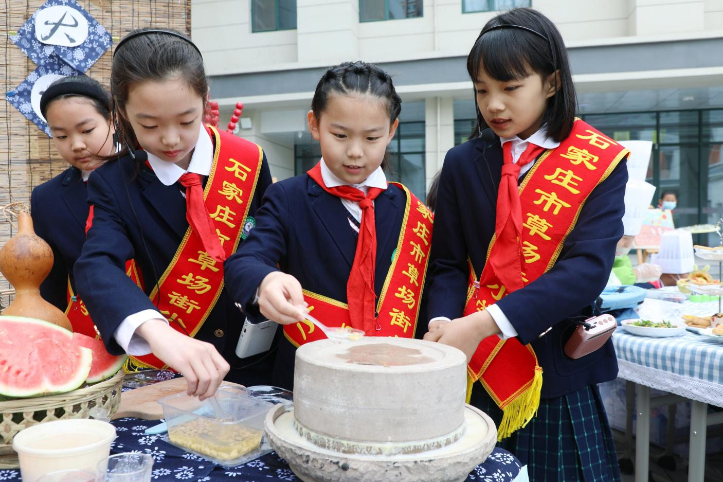 在劳动技能大赛上，学生们体验用石磨磨豆浆。 董璐摄
