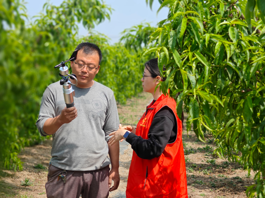 河北省唐山市豐南區氣象局工作人員指導農戶用手持氣象儀監測氣象數據。 畢帥攝