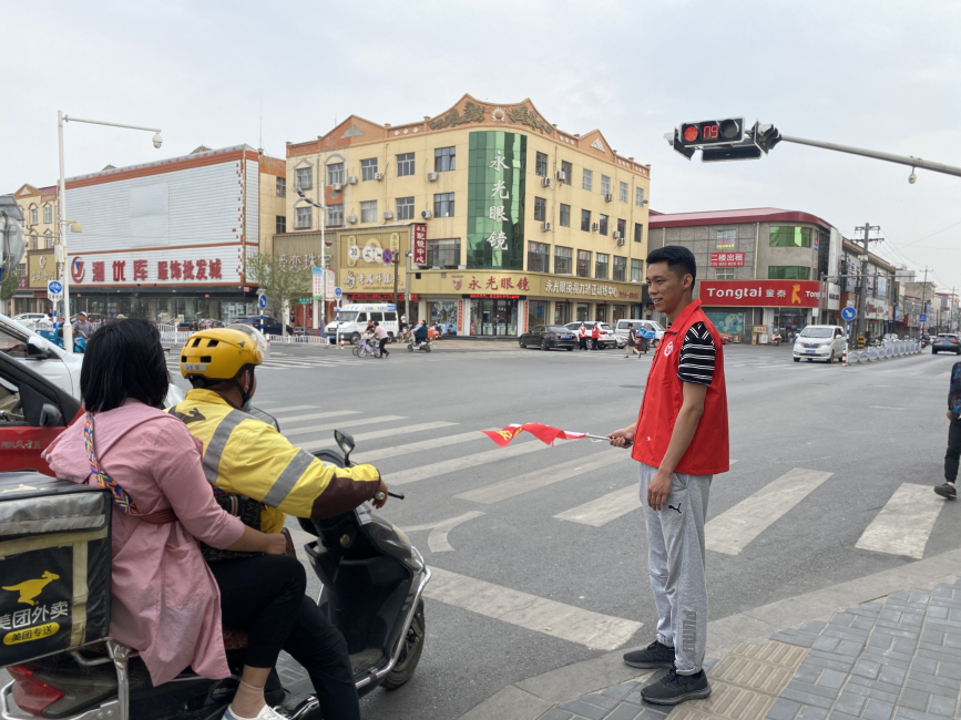 志願者在路口參與交通引導。 張素攝