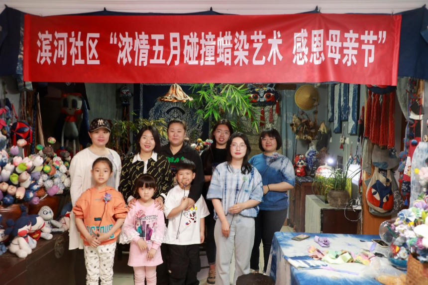 唐山市豐南區濱河社區的孩子們與媽媽共同制作蠟染布藝康乃馨。 王馨瑤攝