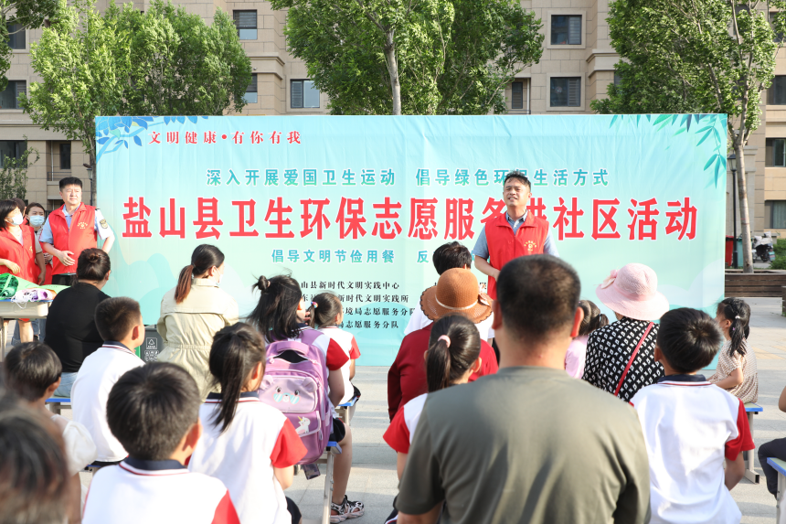 5月16日，鹽山縣書香名邸小區中心廣場上，志願者正在向居民們普及垃圾分類知識。 程一諾攝