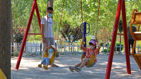 高阳县斗洼村新颖公园内孩子们荡秋千。