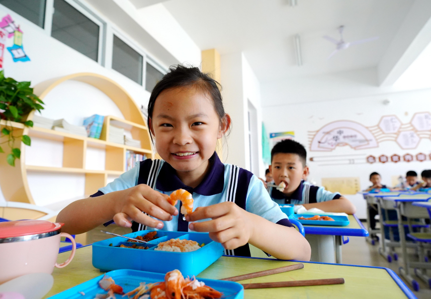 乐亭县第五实验小学的学生正在吃营养午餐。 侯亚婷摄