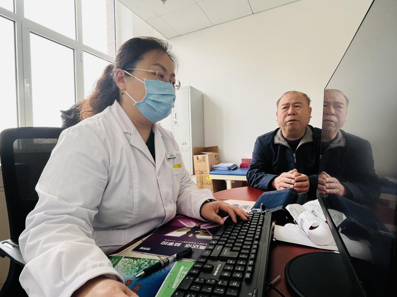 涞水县中医院慢特病服务中心医生正在查看患者刘建成（右一）用药记录。 李金璐摄