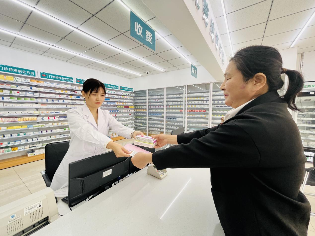 群众正在门诊慢特病统筹结算专区定点药店拿药、报销。 李金璐摄