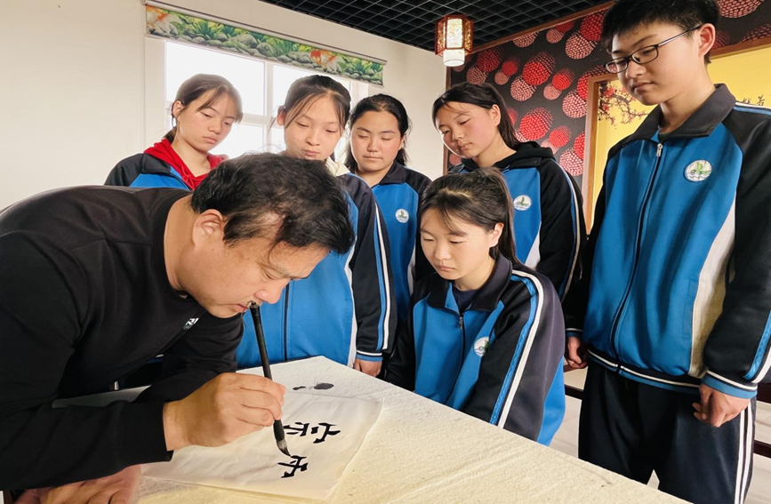 涞水县娄村镇娄村学区校长在书法社团指导学生书写技巧。李金璐摄