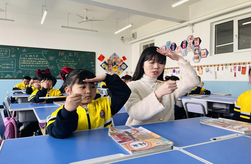涞水县西关小学教师指导一年级学生写字姿势。 李金璐摄