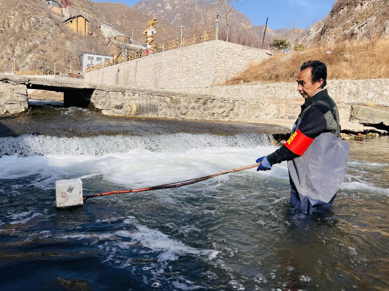 在涞水县拒马河九龙镇北龙门村段，巡河员正在进行河面清漂工作。 谷梓龙摄