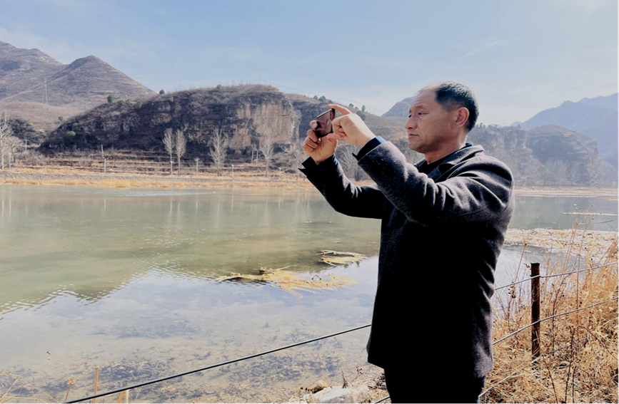 在涞水县拒马河三坡镇松树口村段，村级河长张建国正在通过“河长云”APP上传巡河记录。 谷梓龙摄
