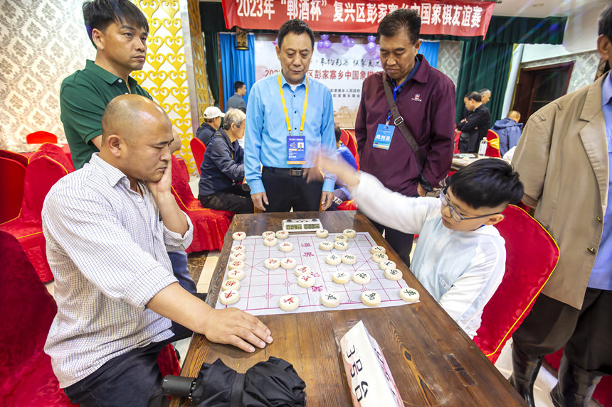 12岁的赵紫砚（右）与彭家寨乡群众比赛中。赵紫砚曾获得2018年全国象棋儿童赛（北方赛区）丁组第一名。 聂长青摄