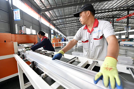 在河北省廊坊市文安县左各庄镇良禾木业有限公司生产车间，工人们正在生产建筑用铝合金模板。王晖摄