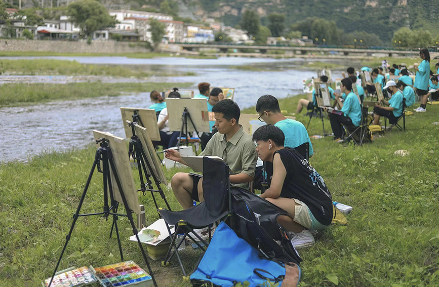 大学生在拒马河畔进行写生创作。 张帆摄