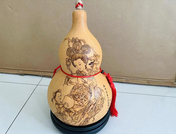 第五小學環保燙畫手工藝術班學生在校園種植的葫蘆上燙出多姿的圖畫，小小葫蘆變成了“藝術品”。 郭晨穎攝