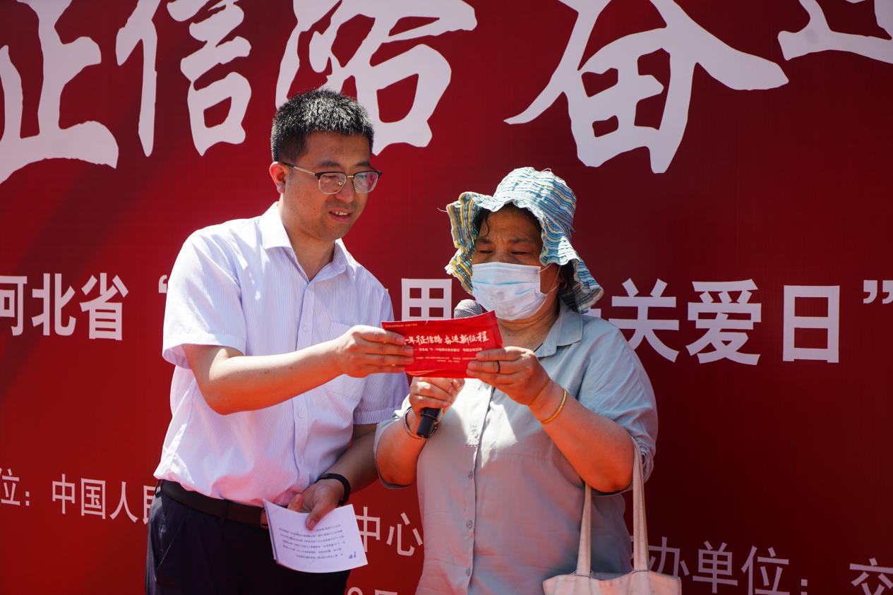 工作人員向群眾發放宣傳折頁，現場講解。 交行河北省分行供圖