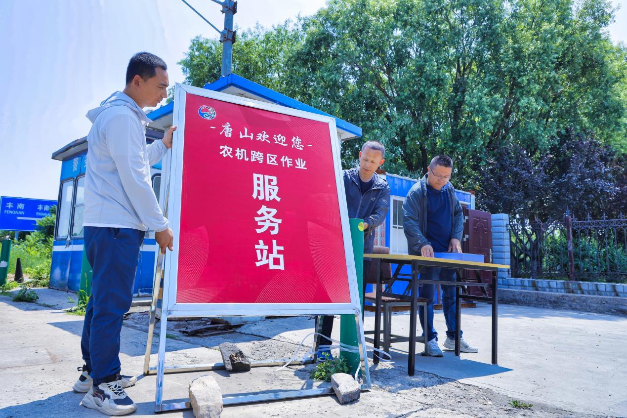 在河北省唐山市丰南工业区高速出口，工作人员正在设置农机跨区作业接待服务站。 毕帅摄