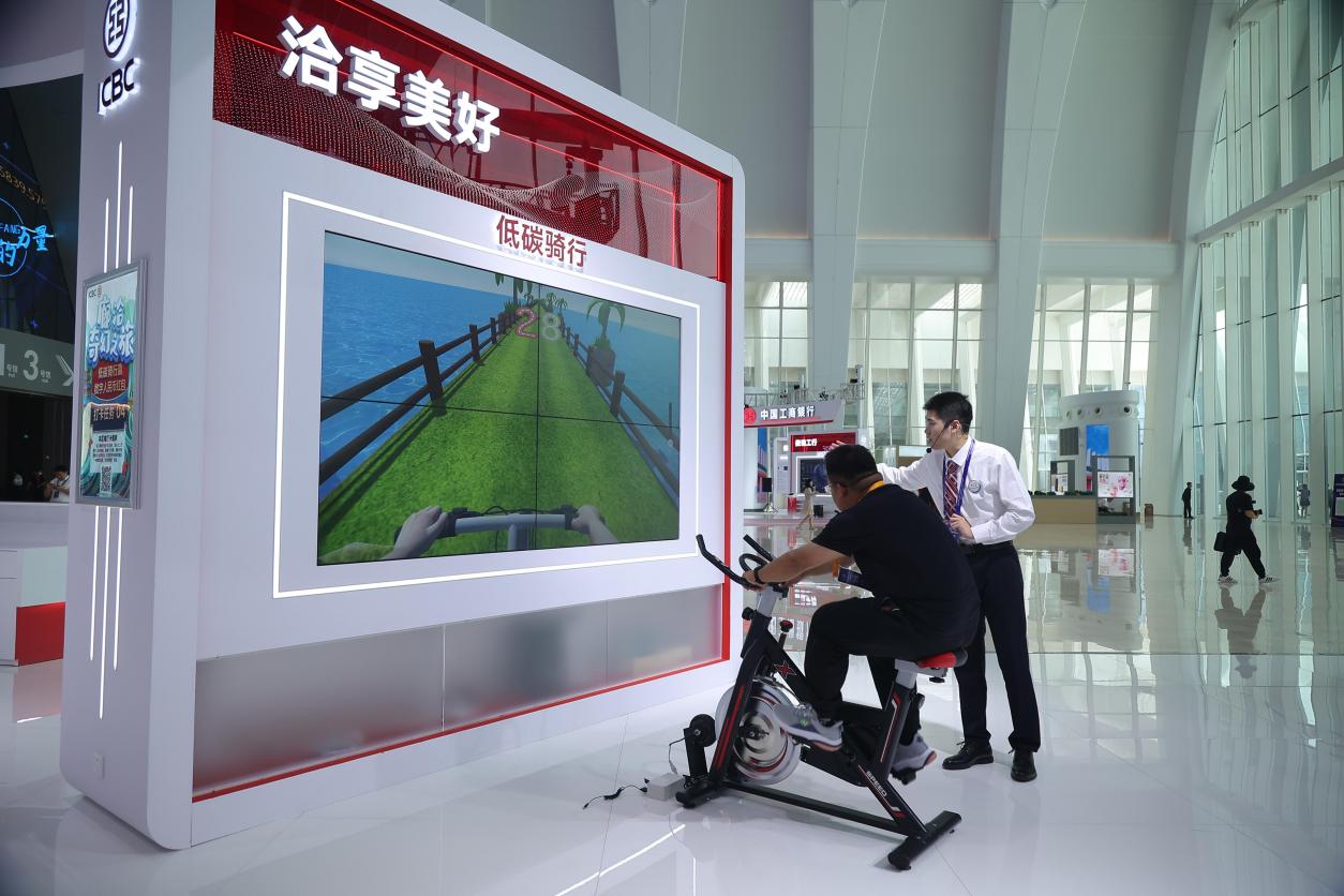 现场观众参与体验低碳骑行模拟项目。 王冠翔摄