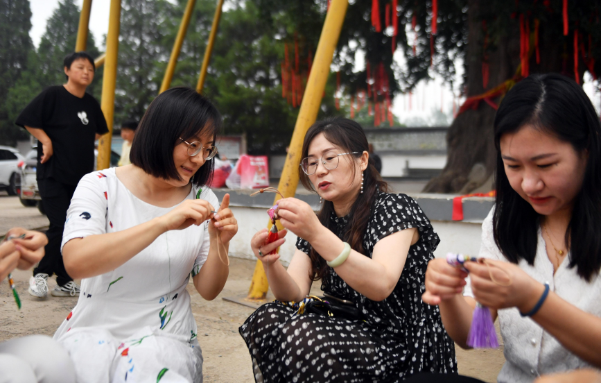 6月19日,迁安市蔡园镇马官营村村民齐聚白果树下,一起做香囊。 彭月娟摄
